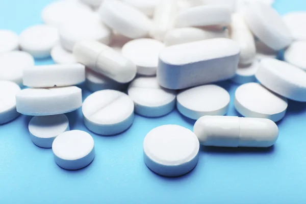 Pile of pills on color table, closeup — Stock Photo, Image