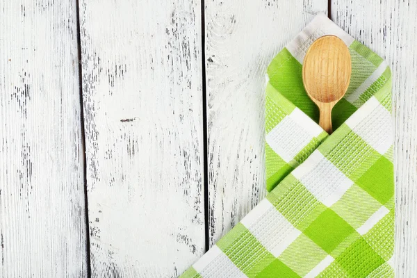 Checkered napkin with spoon on wooden table background — Stock Photo, Image