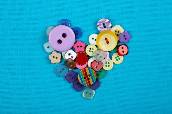 Cucire bottoni cuore su sfondo stoffa — Foto Stock