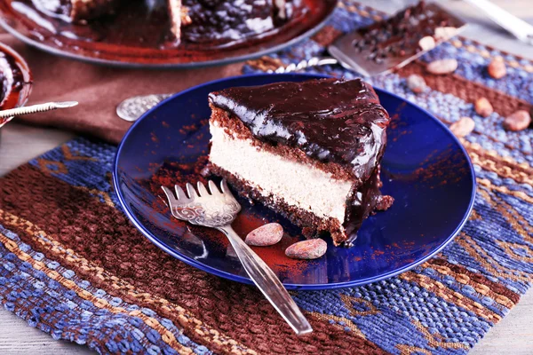 Köstlicher Schokoladenkuchen mit Zuckerguss im Teller auf dem Tisch, Nahaufnahme — Stockfoto