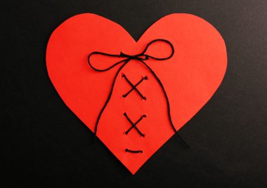 Stitched heart on black background clipart