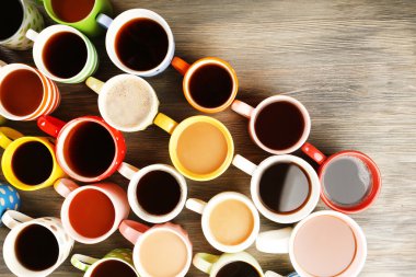 Ahşap masanın üstünde bir sürü kahve fincanı var.