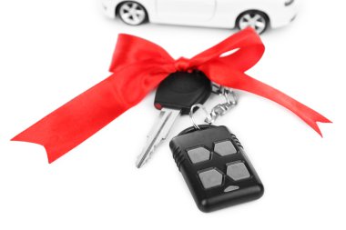 Kırmızı yay ve üzerinde beyaz izole hediyesi olarak araba ile anahtar taşı