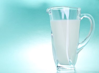 Mavi arka plan üzerinde süt sürahi