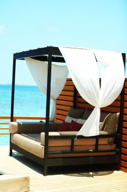 Mavi gökyüzü arka plan üzerinde resort yüzme havuzunda yakınındaki rahat kanepe