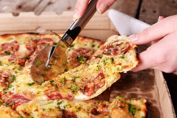 Girl cut pizza on table close up — Stock Photo, Image