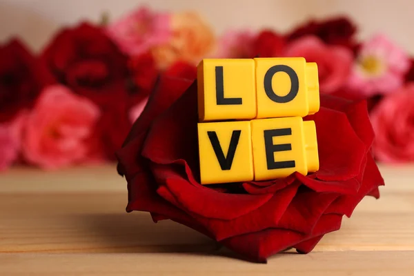 Letras decorativas formando palabra AMOR con flores de cerca —  Fotos de Stock