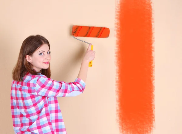 Belle femme peint mur dans la chambre — Photo