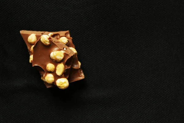 Chocolate com nozes sobre fundo preto — Fotografia de Stock