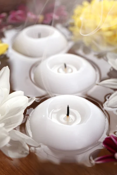 Bollen med spa vann med blomster og stearinlys. – stockfoto