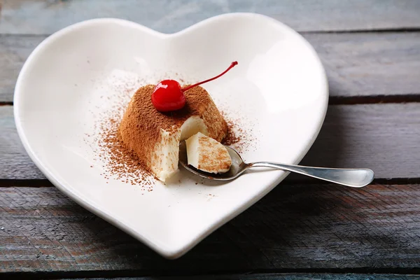 Smakelijke panna cotta dessert op bord, op houten tafel — Stockfoto