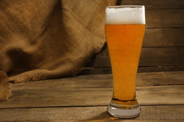 Sklenice piva na dřevěném pozadí — Stock fotografie