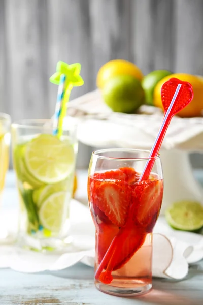 Cocktails with fresh strawberries and lemon lime on wooden background — Stock Photo, Image