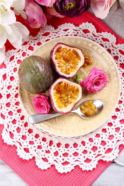 Renkli peçete arka plan üzerinde plaka üzerinde Passion fruit — Stok fotoğraf