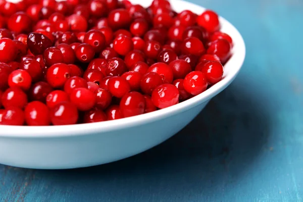 Cranberries in bowl on wooden background — Stock Photo, Image