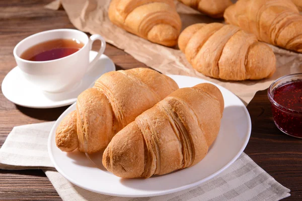 Läckra croissanter på tallrik — Stockfoto