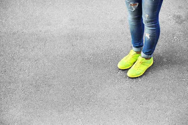 Kobiece stopy nad szary asfalt — Zdjęcie stockowe
