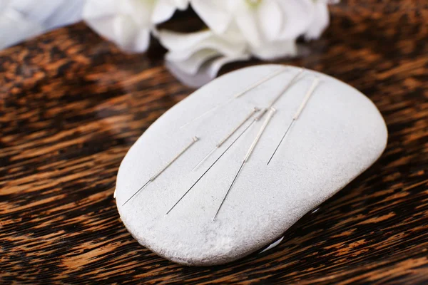 Acupuncture needles on spa stone — Stock Photo, Image
