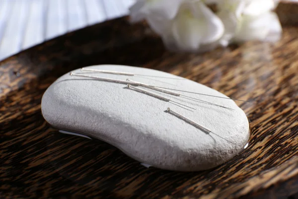 Acupuncture needles on spa stone — Stock Photo, Image