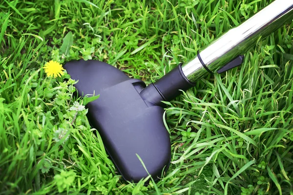 Pipa logam penyedot debu dalam aksi karpet bersih rumput hijau nyata. Konsep ekologi — Stok Foto