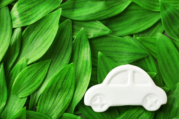 Coche de juguete en hojas verdes —  Fotos de Stock