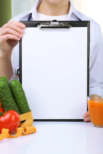 Ernährungsmediziner mit Klemmbrett für Diätplan im Büro — Stockfoto