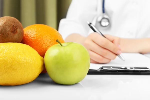 Nutricionista médico escribir plan de dieta en el consultorio —  Fotos de Stock