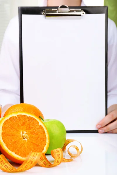 Nutricionista médico con portapapeles para plan de dieta en el consultorio — Foto de Stock