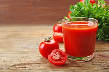Bardak taze domates suyu ahşap arka plan üzerinde