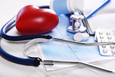 Kardiyogram masada, closeup stetoskop ve kırmızı kalpli