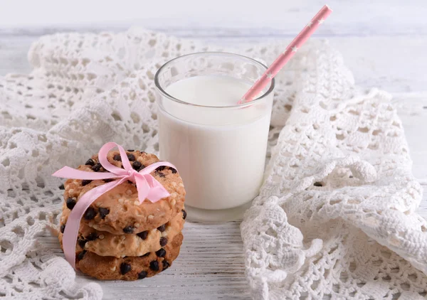 Смачне печиво та склянка молока на кольоровому дерев'яному фоні — стокове фото