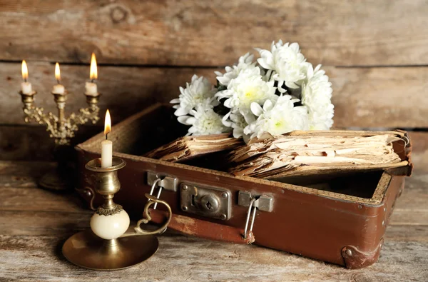 Old wooden suitcase with old books and flowers on wooden background — Stock Photo, Image