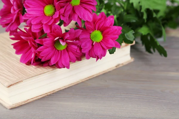 Beautiful flowers and book on table, close-up — Stock Photo, Image