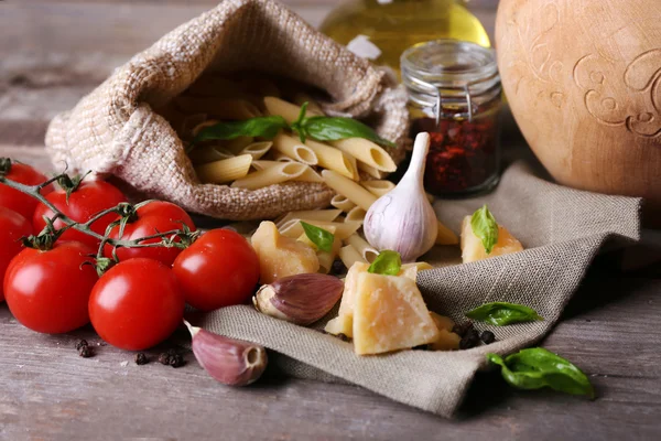 Pâtes aux tomates cerises et autres ingrédients sur fond de table en bois — Photo