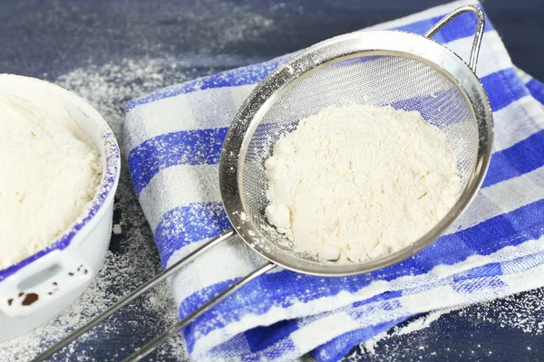 Sifting flour through sieve on wooden table, closeup — Stock Photo, Image