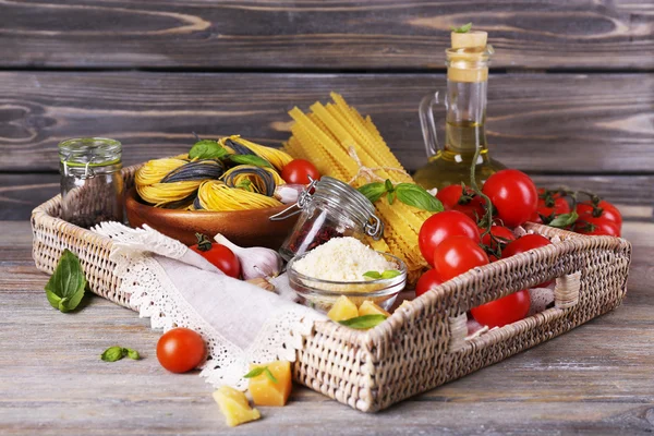 Pasta met cherry tomaten en andere ingrediënten op houten planken achtergrond — Stockfoto