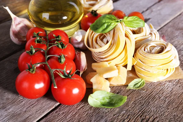 Pasta con pomodorini e altri ingredienti su fondo tavola in legno — Foto Stock