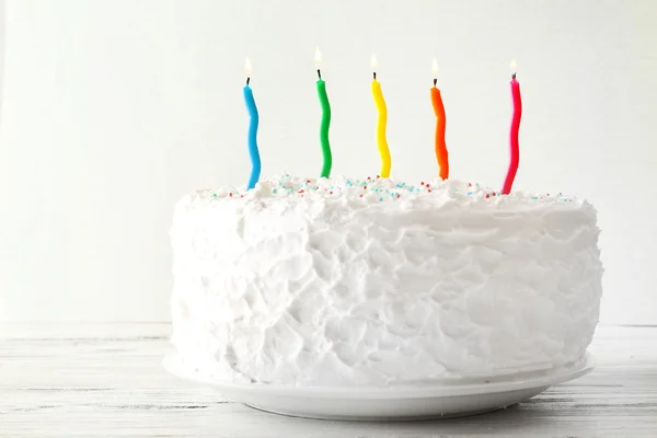 Torta di compleanno con candele su sfondo a colori — Foto Stock