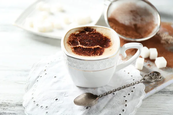 Xícara de café arte latte na mesa de madeira, no fundo claro — Fotografia de Stock