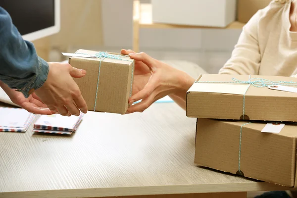 Frau gibt Paket in Postfiliale ab — Stockfoto