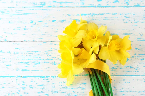 Hermoso ramo de narcisos amarillos sobre fondo de madera — Foto de Stock