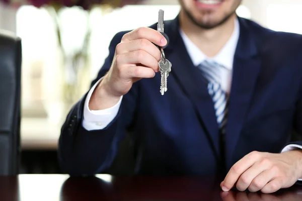 Affärsman med nycklarna i handen i office — Stockfoto