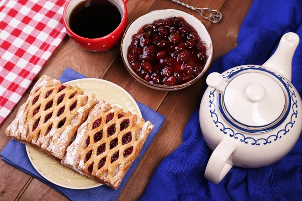 Pieczenia, herbaty i dżem na drewnianym stole widok z góry — Zdjęcie stockowe