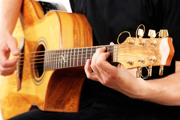 Young man playing on acoustic guitar close up — Stock Photo, Image