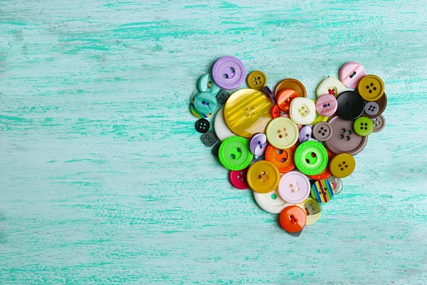 Cucire bottoni cuore su sfondo di legno — Foto Stock