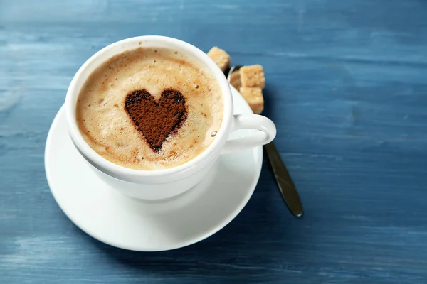 Xícara de cappuccino com coração de cacau na mesa de madeira — Fotografia de Stock