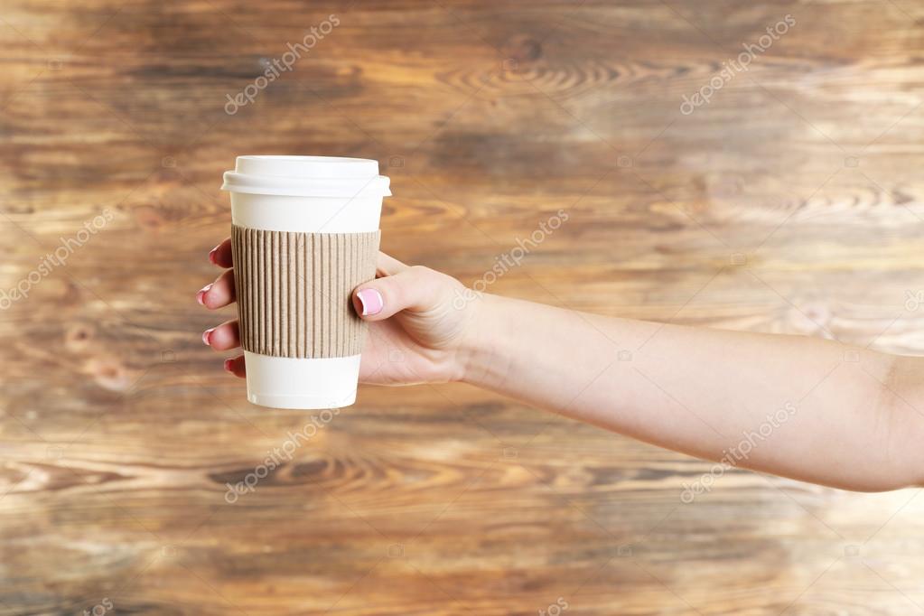 Female hand with paper cup on wooden background Stock Photo by ...