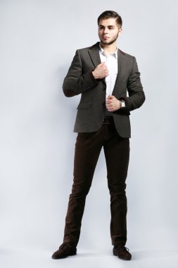gri arka plan üzerinde takım elbiseli şık adam