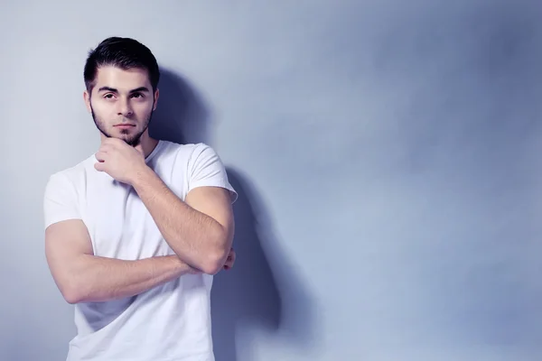 Portrait of young man on gray background — Stock Photo, Image