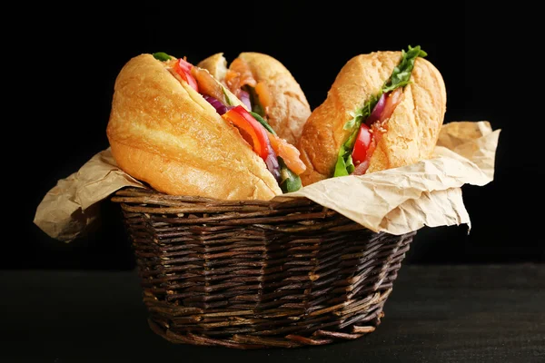 Sandwiches with salmon in wicker basket, on dark background — Stock Photo, Image